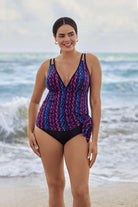 Woman on beach wearing a purple and blue stripey pattern swim dress