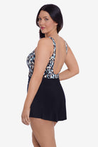 Woman faced left wearing a leopard printed swim romper with black shorts