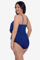 Woman faced left wearing a navy-blue tiered ruffle tankini top