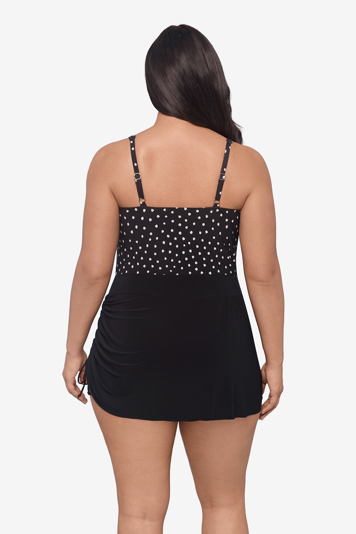 Woman faced away wearing a black and white lace-esque pattern swim romper