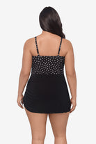 Woman faced away wearing a black and white lace-esque pattern swim romper