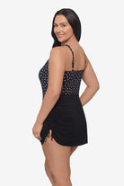 Woman turned left wearing a black and white lace-esque pattern swim romper