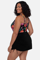 Woman turned left wearing a pink and orange floral printed swim dress
