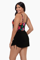 Woman turned left wearing a swim dress with a floral pattern on the bust