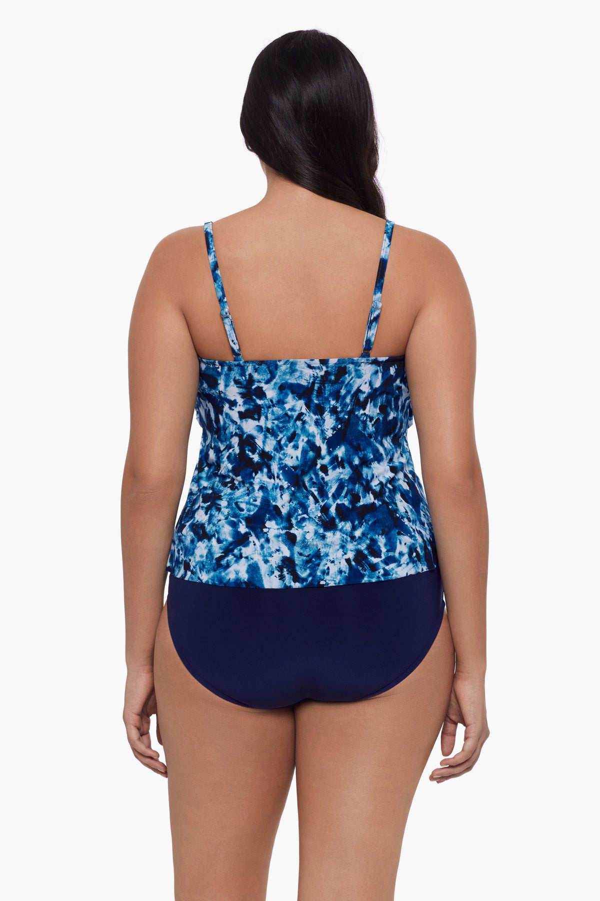 Woman turned away wearing a tankini top with a blue tie dye print