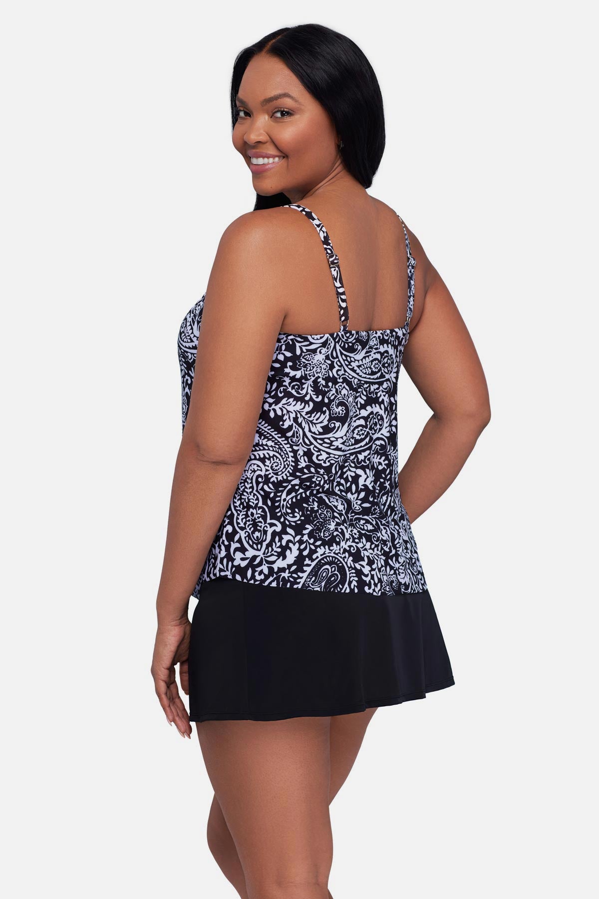 Woman turned left wearing a black and white paisley printed tankini top