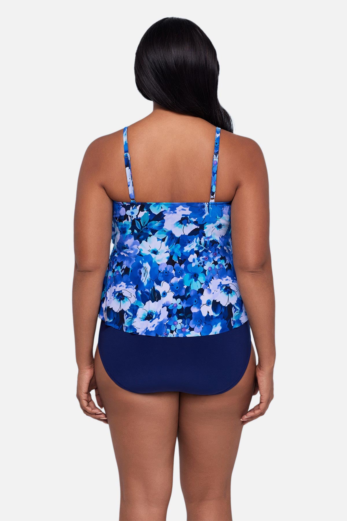 Woman turned away wearing a blue and white floral pattern tankini top