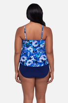Woman turned away wearing a blue and white floral pattern tankini top