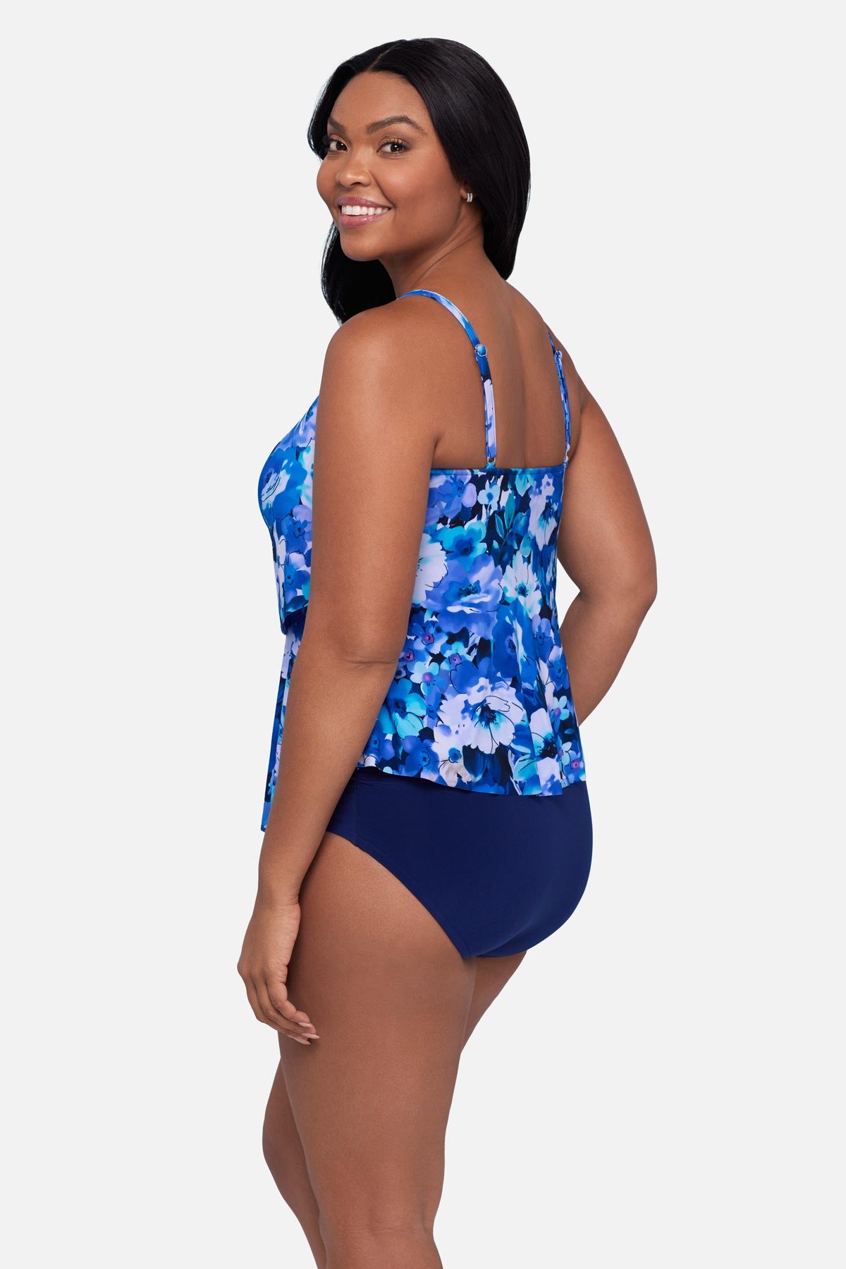 Woman turned left wearing a blue and white floral pattern tankini top