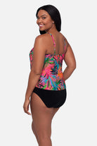 Woman turned left wearing a multicolored palm leaf printed tankini top with ruffles