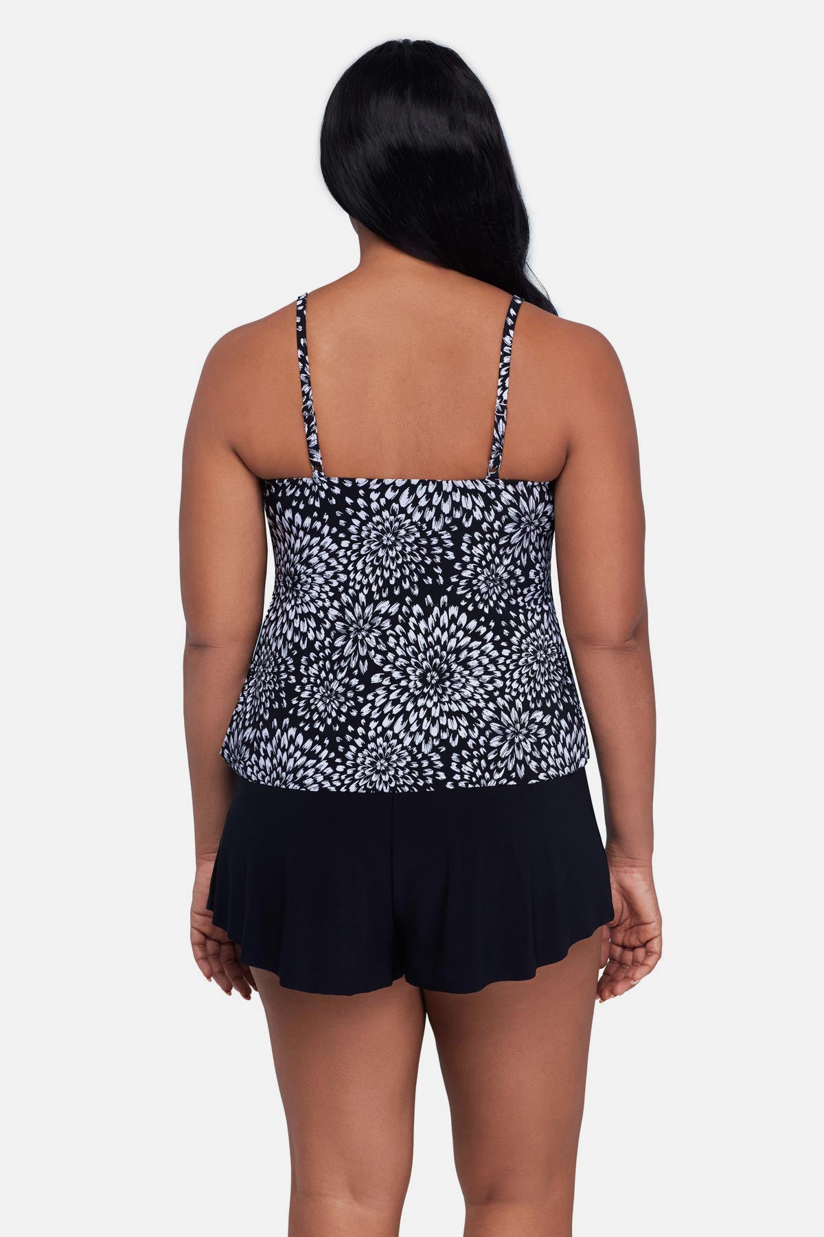 Woman turned away wearing a black and white floral printed tankini top 
