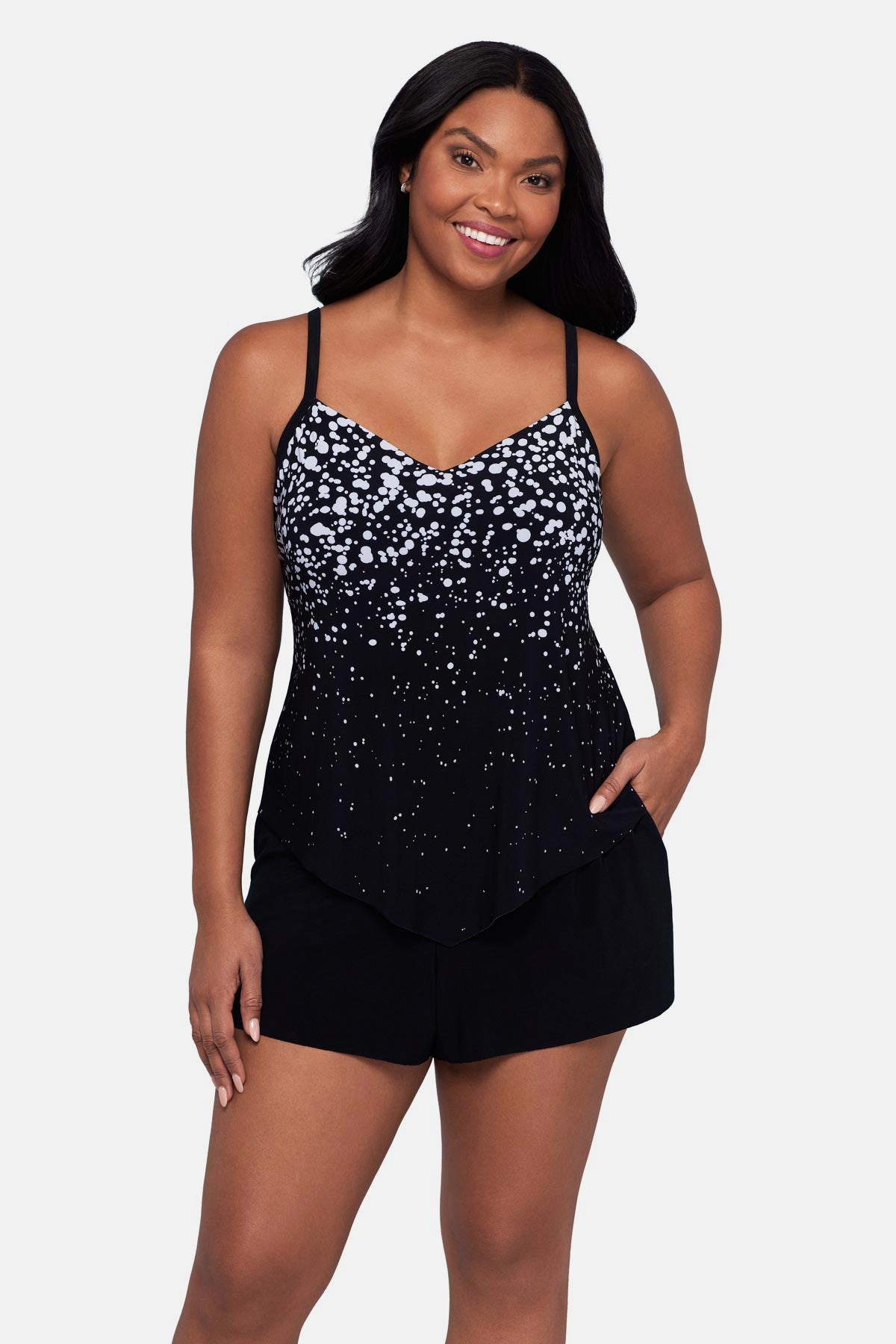Woman wearing a black and white dot printed romper swimsuit