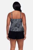 Woman turned away wearing a black and white floral printed swim romper