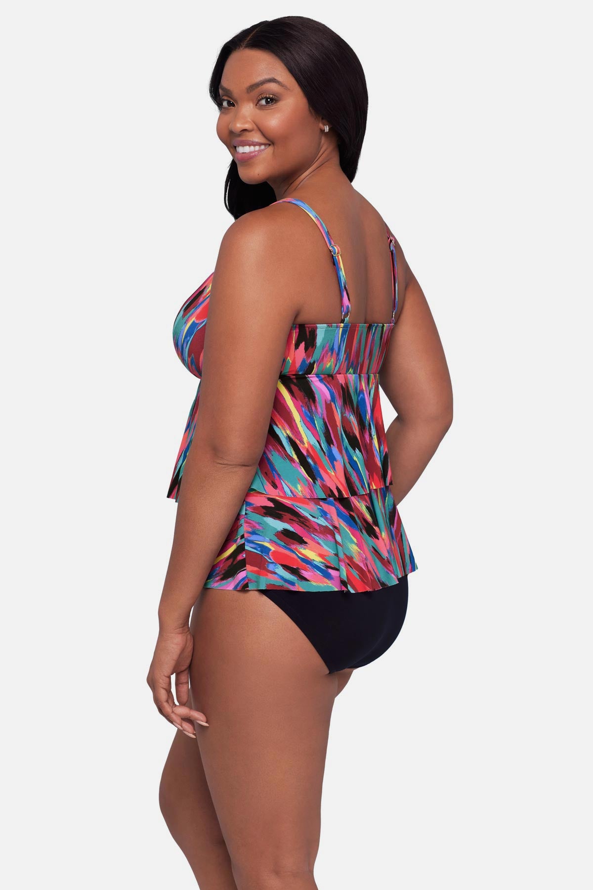 Woman turned left wearing an abstract multicolored printed tankini top with ruffles