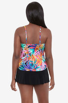 Woman turned away wearing a multicolored palm leaf pattern ruffled tankini top