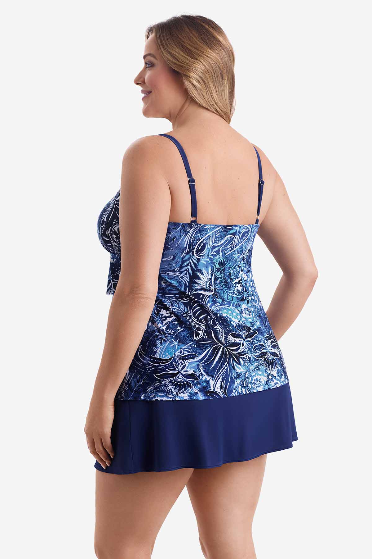 Woman turned left wearing a tiered one-piece swimsuit with an abstract blue pattern
