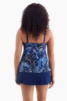 Woman turned away wearing a one-piece swimsuit with a blue abstract floral print