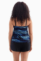 Woman faced away wearing a one-piece tiered swimsuit with a black and blue print