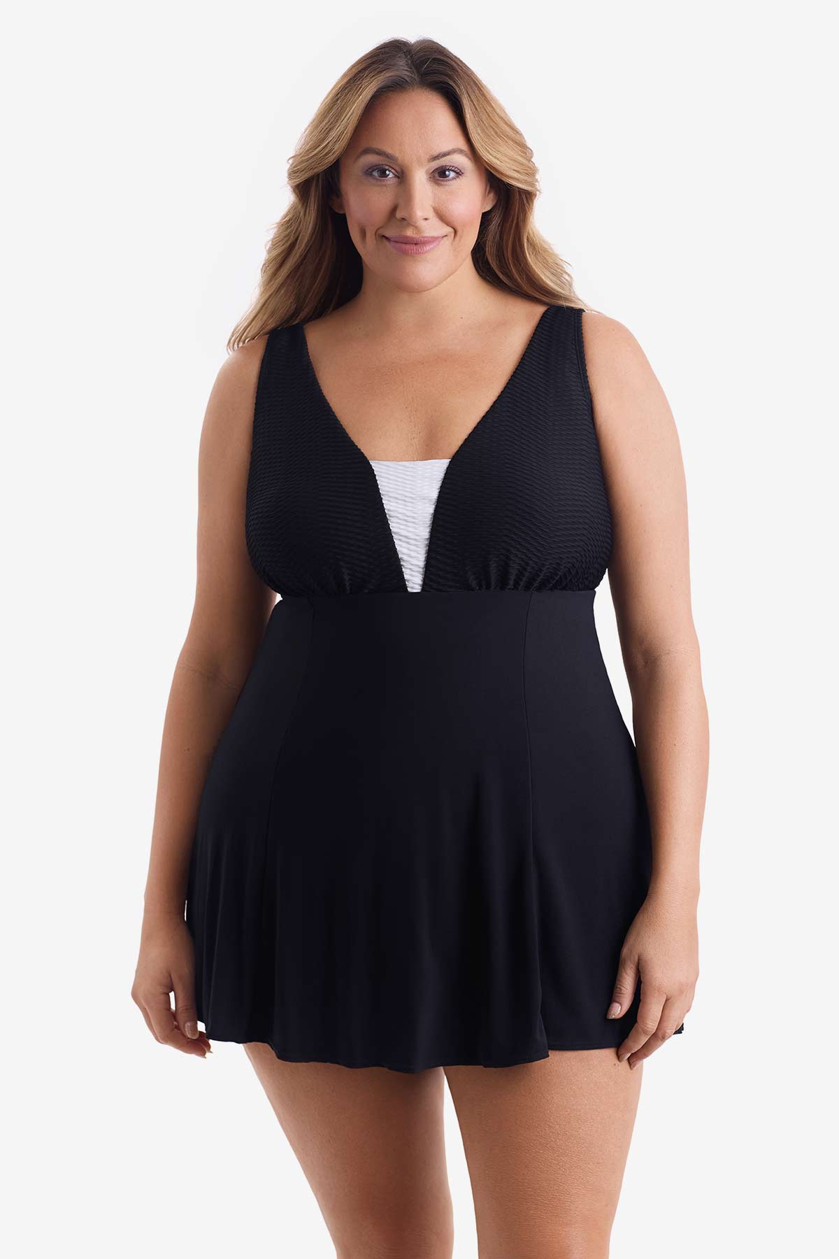 Woman wearing a black swim dress with a white panel on the bust