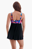 Woman faced away wearing a swim dress with a multicolored pattern on the back
