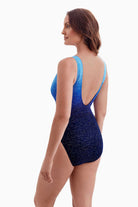 Woman turned left wearing a blue ombre one-piece swimsuit with sparkle detail