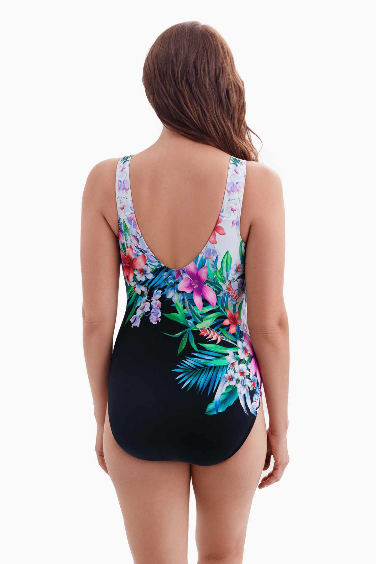 Woman turned away wearing half white half black one-piece swimsuit with a floral print running through the middle