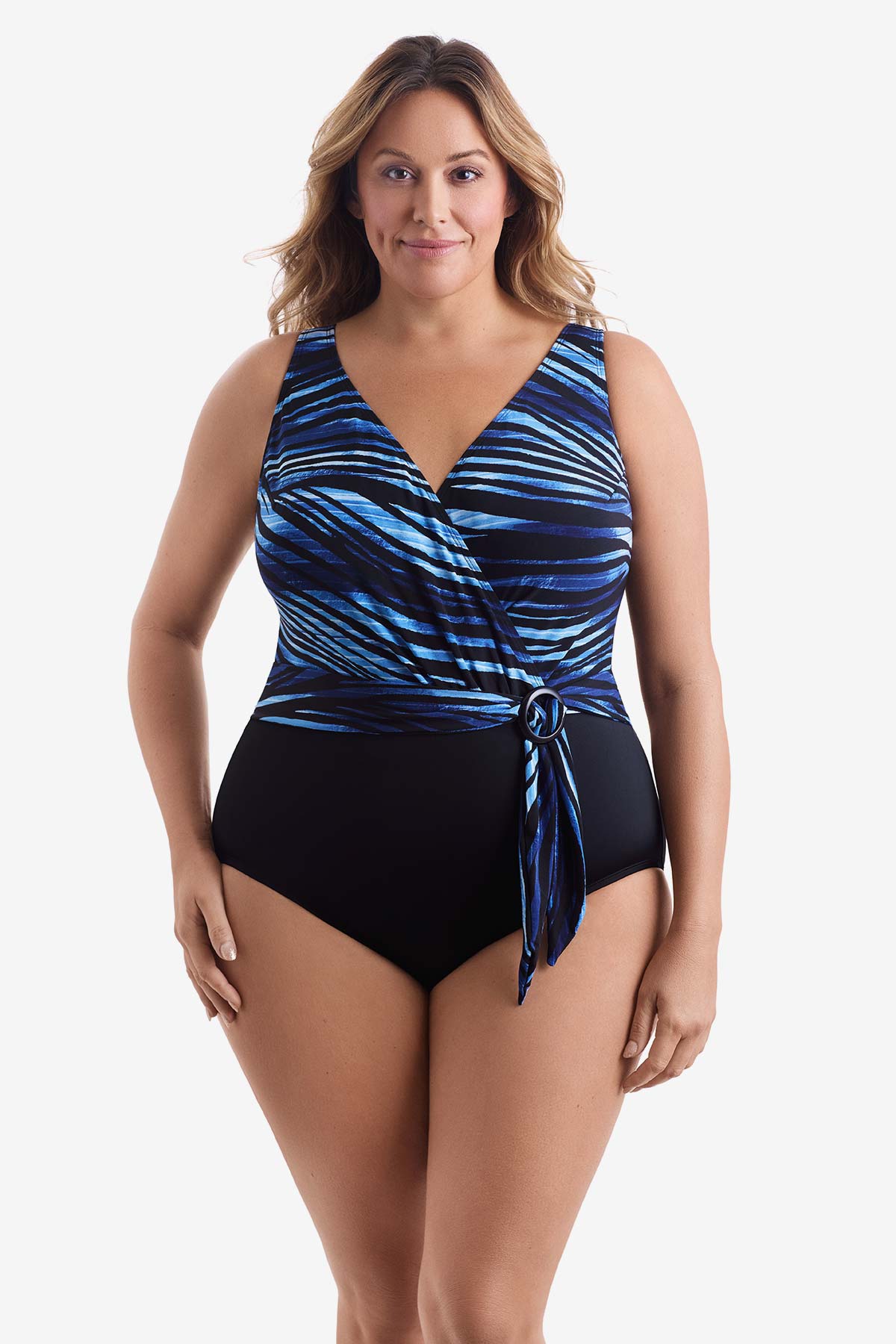 Woman wearing a black and blue striped one-piece swimsuit with a belted detail
