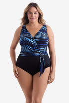 Woman wearing a black and blue striped one-piece swimsuit with a belted detail