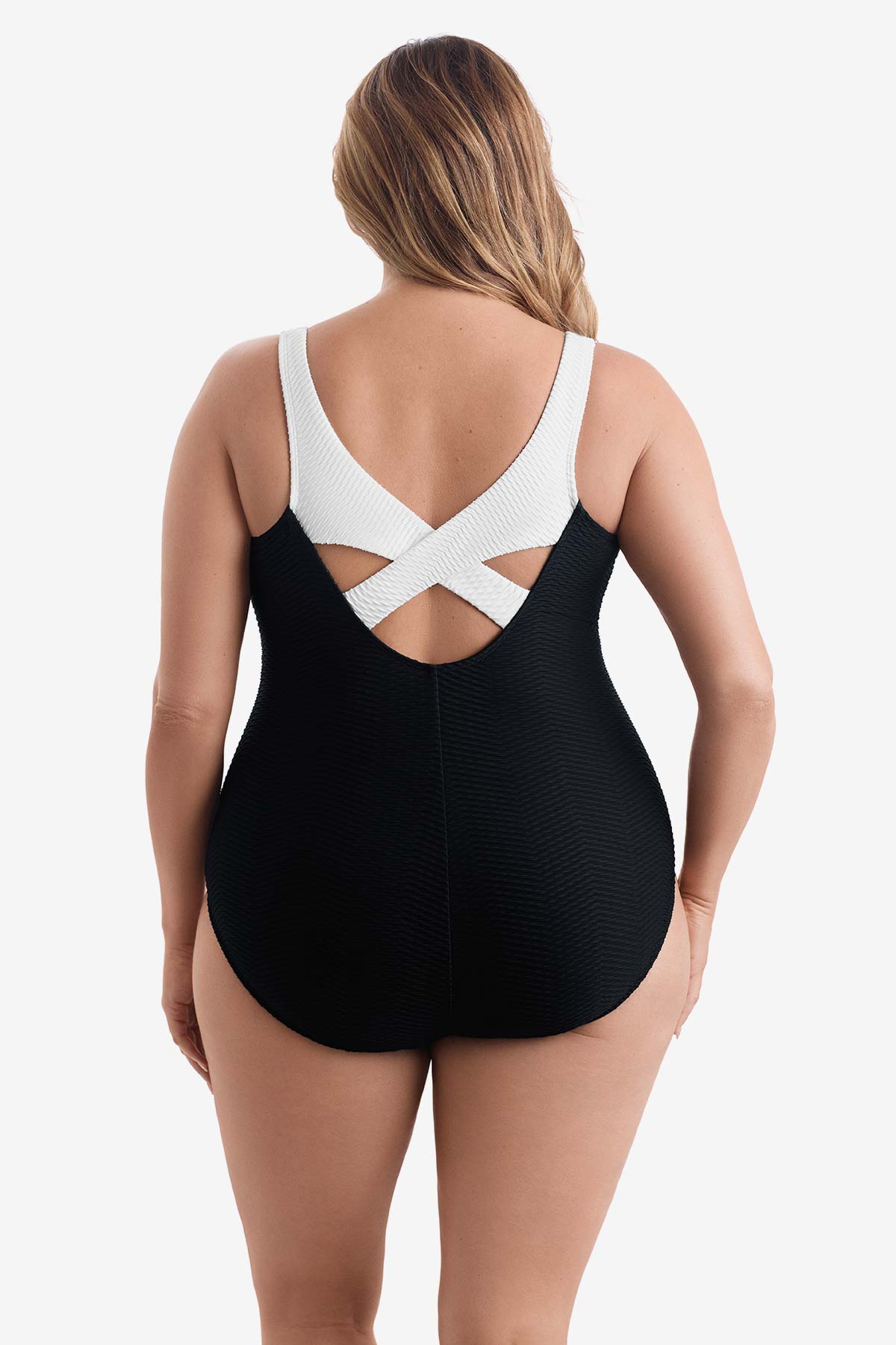 Woman turned away wearing a black one-piece swimsuit with white on the X back