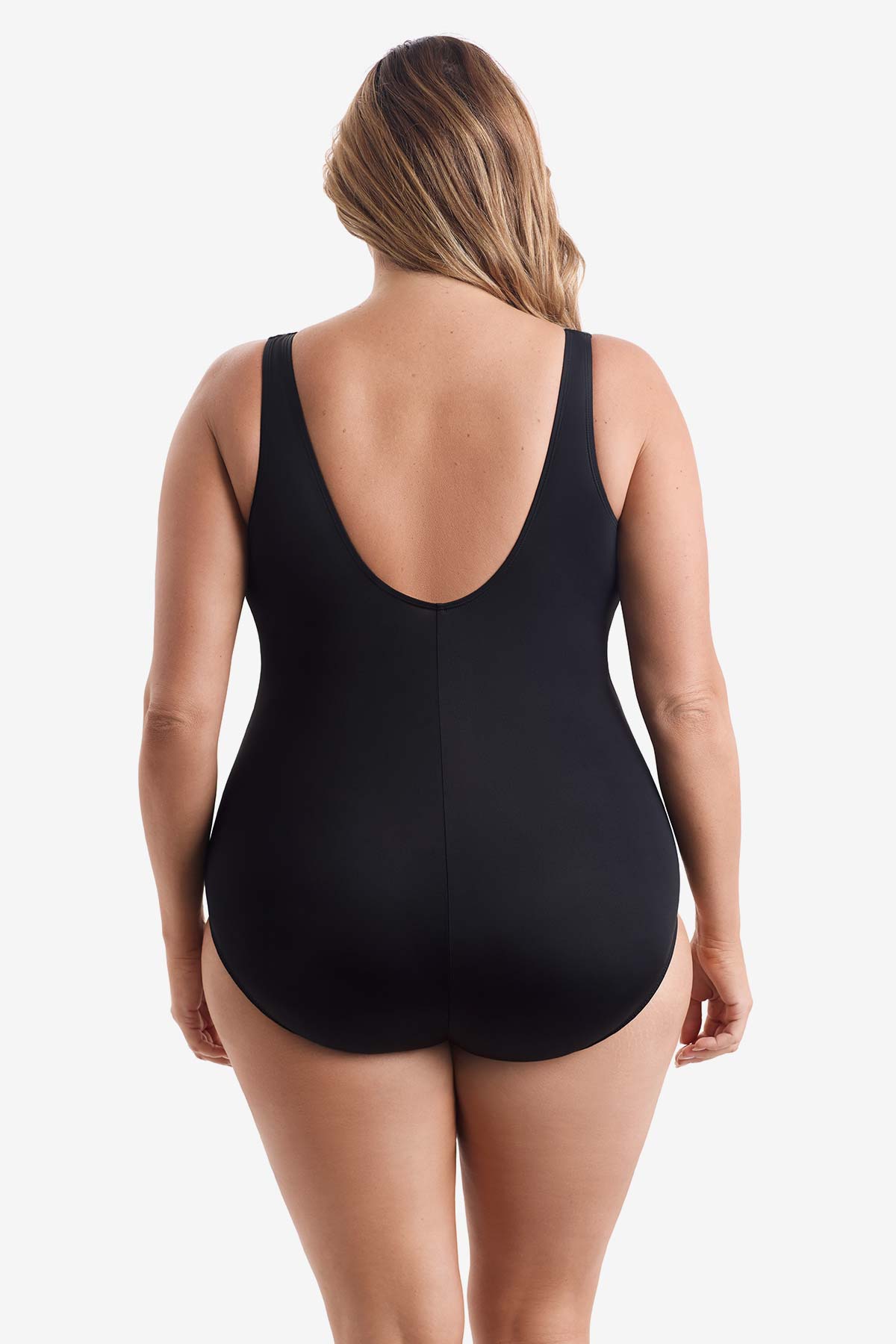 Woman faced away wearing a black and white leaf printed one-piece swimsuit