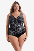 Woman wearing a black and white leaf printed one-piece swimsuit