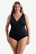 Woman wearing a black one-piece swimsuit with an O ring detail on the side