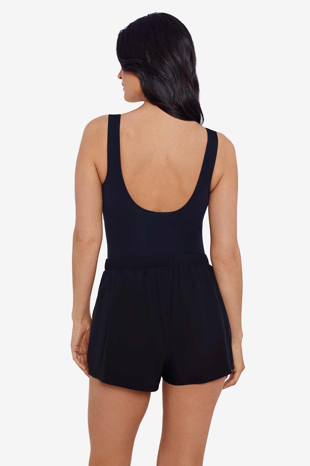 Woman faced away wearing a black romper one-piece swimsuit
