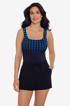 Woman wearing a black and blue faded dot print romper one-piece swimsuit