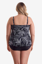 Woman faced away wearing a black and white leaf pattern tankini top 