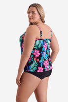 Woman faced left wearing a multicolored tropical printed tankini top