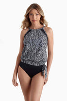 Woman wearing a blouson style tankini top with a black and white pattern