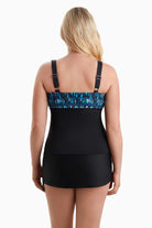 Woman faced away wearing a tankini top with a blue pattern along the back