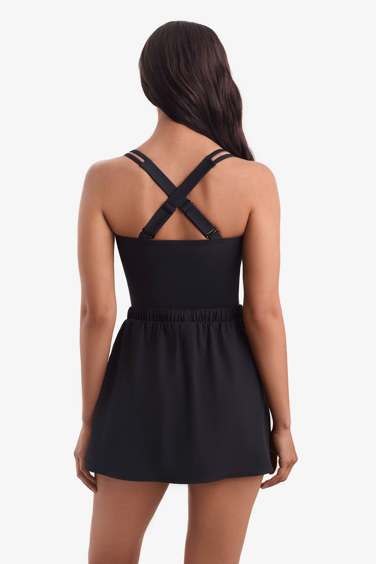 Woman turned away wearing a one-piece skirted swimsuit