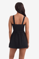 Woman turned away wearing a one-piece skirted swimsuit