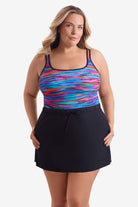Woman wearing a multicolored streaked print one-piece skirted swimsuit