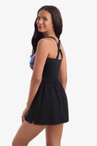 Woman turned left wearing a multicolored streaked print one-piece skirted swimsuit