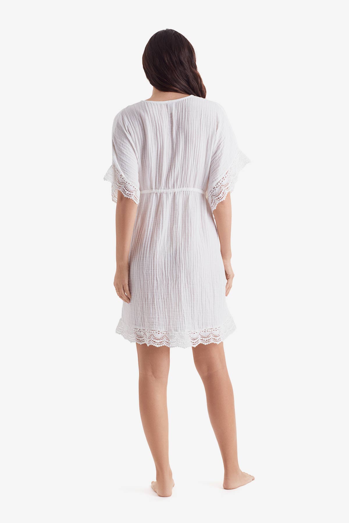 Woman faced away wearing a white tunic dress