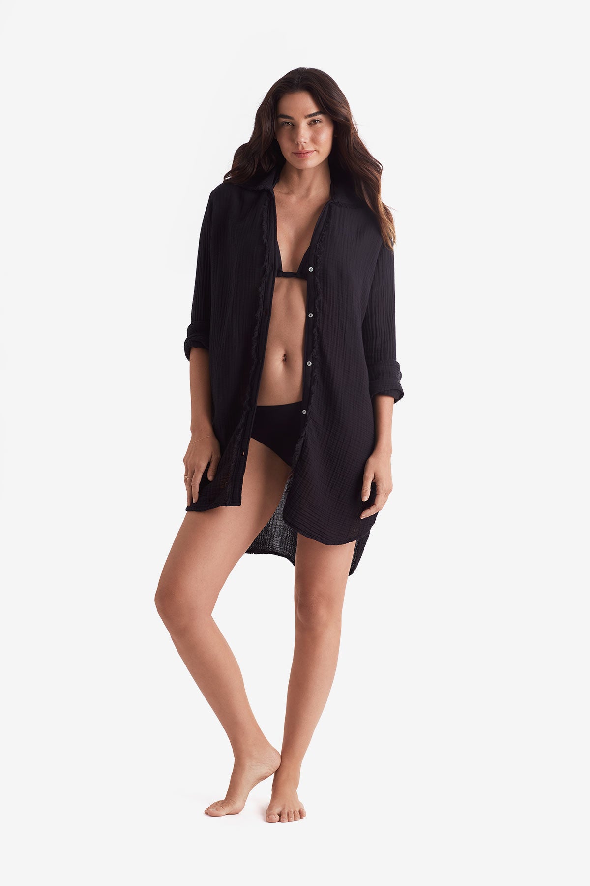 Woman wearing a black long sleeve button up shirt unbuttoned