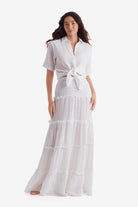 Woman wearing a white short sleeve button up and white floor length skirt
