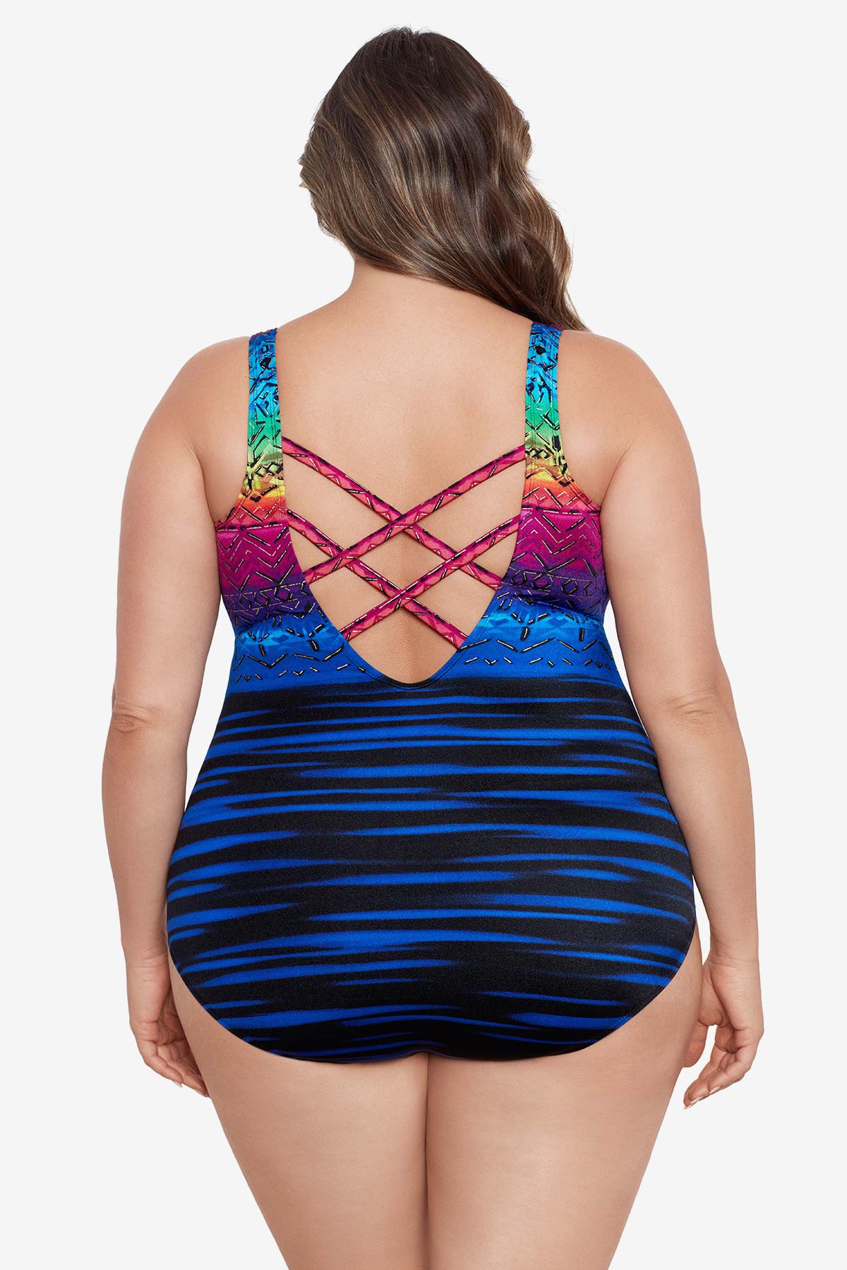 Woman faced away wearing a rainbow ombre with a geometric overlay print one-piece swimsuit