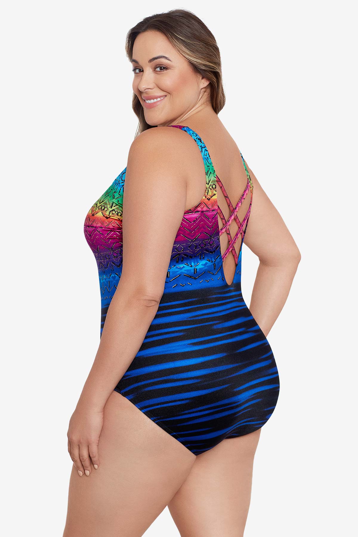 Woman faced left wearing a rainbow ombre with a geometric overlay print one-piece swimsuit