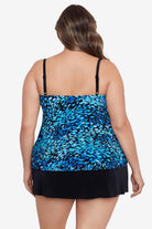 Woman turned away wearing a black and blue petal pattern ruffle faux skirtini one-piece swimsuit