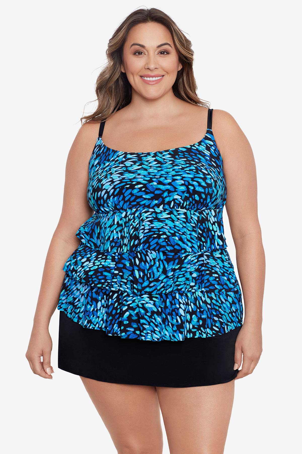 Woman wearing a black and blue petal pattern ruffle faux skirtini one-piece swimsuit