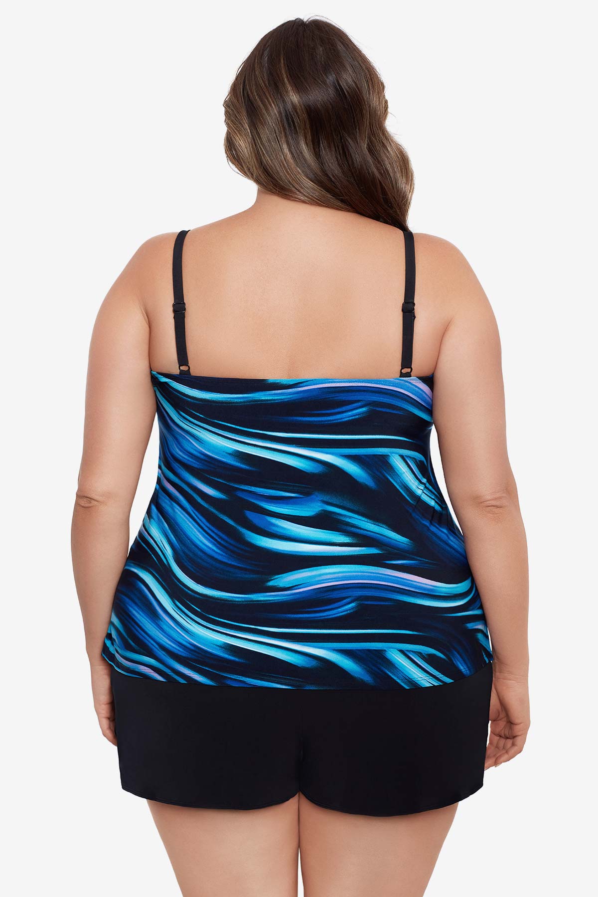 Woman turned away wearing a black and blue oil slick print ruffle tiered one-piece swimsuit shortini